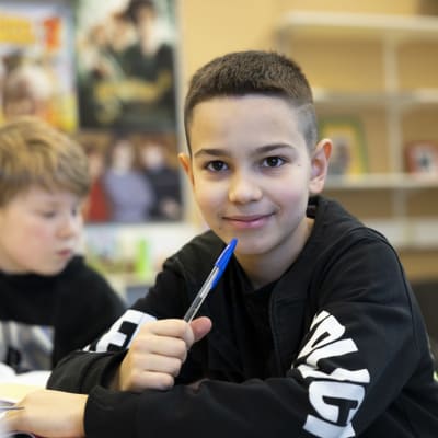 Ukranalainen poika katsoo kameraan koulussa.