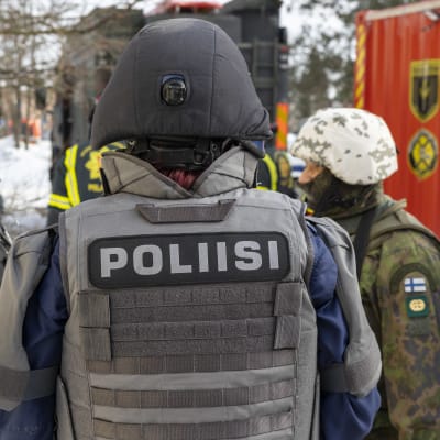 Poliisin suojaliivi takaa. 