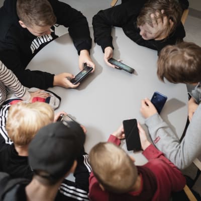 Pojat pelaavat kännyköillä ylä-asteen välkällä 16.9.2019.