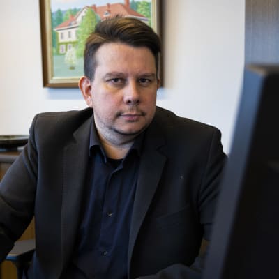 Janakkalan kunnanjohtaja Reijo Siltala istuu työpöytänsä ääressä ja selaa tietokonetta. 