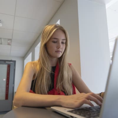 Riihimäen lukion opiskelija Hilla Paukkunen istuu tietokoneen ääressä ja opiskelee.