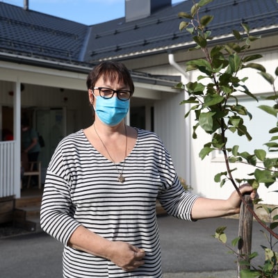 Hoivakodin johtaja Sisko Ratilainen seisoo hoivakodin sisäänkäynnin edustalla.
