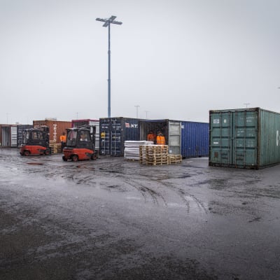 Containrar uppradade på en regnblöt kaj i Nordsjö hamn. 