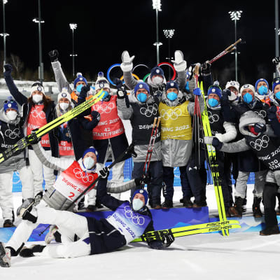 Iivo Niskanen och Joni Mäki firar med det finländska landslaget efter sitt OS-silver i sprintstafett.