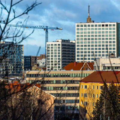 Tiivis kaupunkimaisema talvisessa valossa, suuri ostoskeskus hallitsee maisemaa.