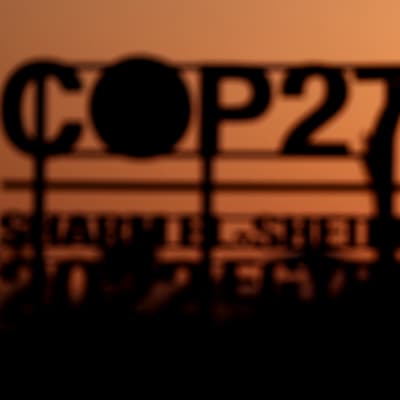 COP27-skylt fotograferad mot solnedgång.