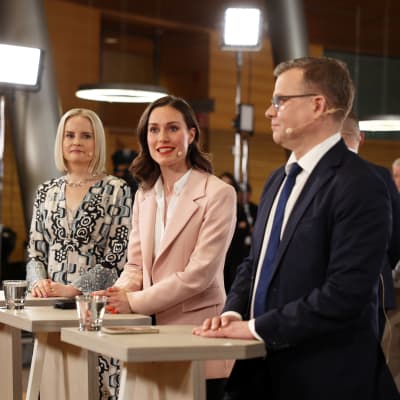 Riikka Purra, Sanna Marin och Petteri Orpo på rad.