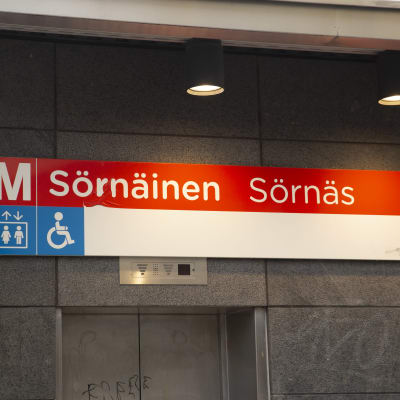 Skylt på Sörnäs metrostation med texten Sörnäinen Sörnäs och ett stort M till vänster om texten