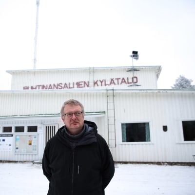 Suomussalmen pienpetopyynnin kilpailun järjestäjä Jarmo Heikkinen seisoo lumisella pihalla kylätalon edustalla.