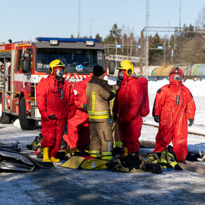 Palomiehiä valmistaumassa kemikaalivuodon hoitamiseen Vainikkalan ratapihalla pelastusharjoituksessa.