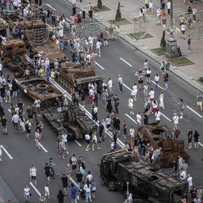Ihmiset tutkivat Kiovaan esille tuotuja tuhottuja Venäjän sotilasajoneuvoja.