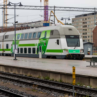 Kaksikerroksinen pendoliino -juna Tampereen rautatieasemalla. Etualalla tyhjiä raiteita.