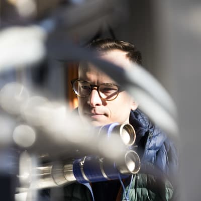 VTT:n VTT:n tutkimusaluejohtaja Antti Arasto tarkastelee polttokennoa Otaniemen laboratorion pihalla.