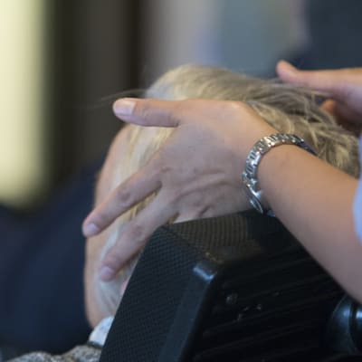 Hemvårdare berör äldre klients hår.