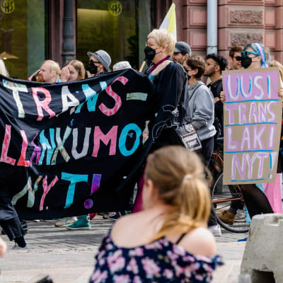 Mielenosoittajien kylteissä lukee "Trans-vallankumous nyt" ja "Uusi translaki nyt!".
