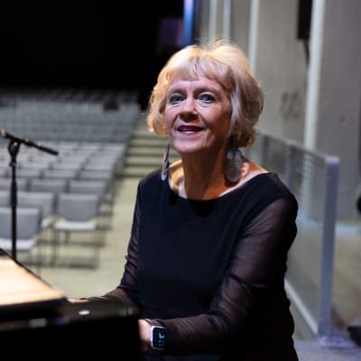 Kuoronjohtaja Marjukka Riihimäki pianon äärellä