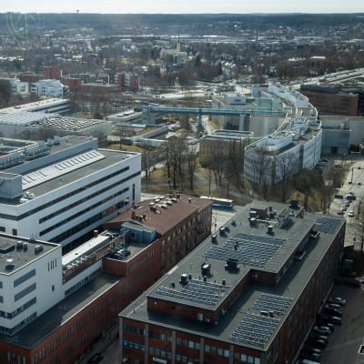 YTHS:n rakennukset kuvattuna yläilmoista, korkealta savupiipusta. Taustalla näkyy myös Tampereen yliopiston rakennuksia ja Tamperetta.