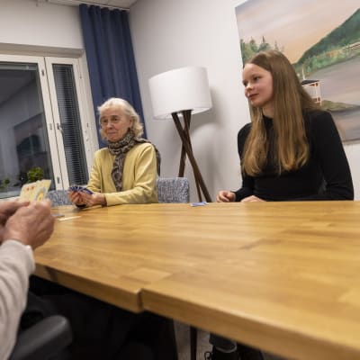 Talon asukas Sirpa Paltemaa pelaa korttia yhdessä Vilma Isoahon kanssa.