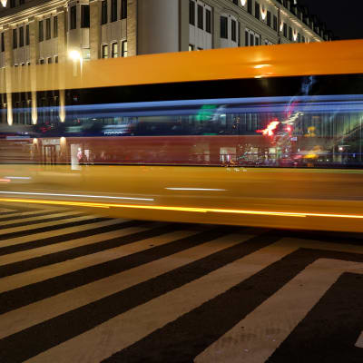 En gul buss kör i mörker i Åbo centrum. 