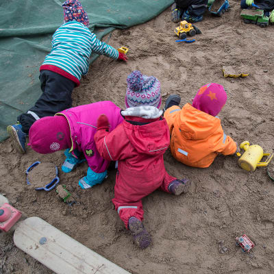 Barn leker i sandlåda