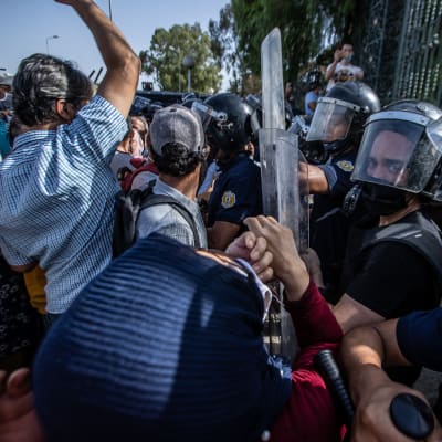 Protester utanför parlamentsbyggnaden i Tunis. Polisen sammardrabbar med demonstranter.