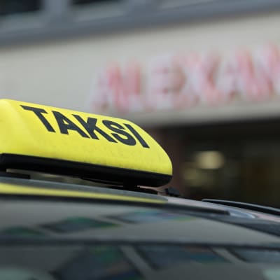 Taksin katolla oleva kyltti lähikuvassa.