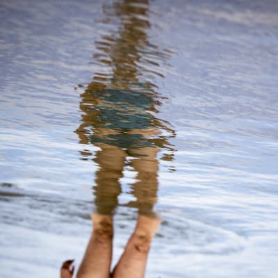 Kuvituskuva uimarin heijastus vedessä, saa kääntää oikeinpäin