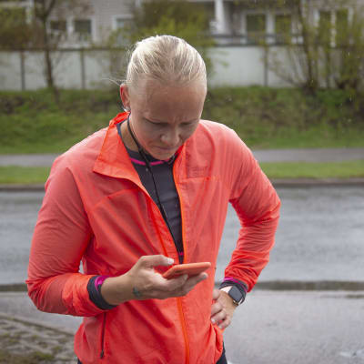 Amanda Kainulainen kollar mobilappen för att se hur snabbt hon löpt.
