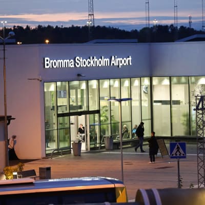 Byggnad där en stor del av väggen på ena sidan består av fönsterglas. Ovanför glasväggen finns texten Bromma Stockholm Airport.
