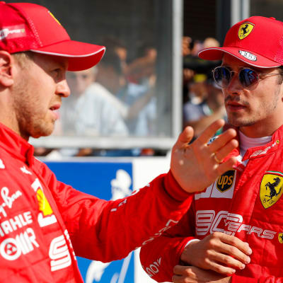 Sebastian Vettel och Charles Leclerc talar med varandra.