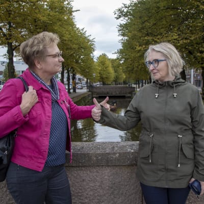 Rauman lastensuojelun päällikkö Johanna Ylikoski ja konsultoiva sosiaalityöntekijä Tiina Ojansuu näyttävät peukut toisilleen. Rauman kanaali näkyy takana.
