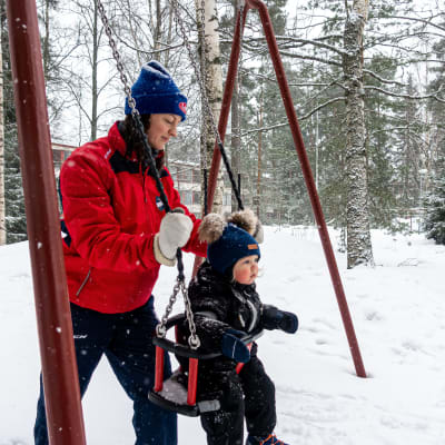 HIFK:n Mia Heikuri Otto-pojan kanssa leikkipuistossa keinumassa.