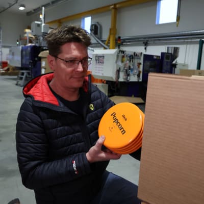 Frisbeegolfkiekkoyrittäjä Timo Nuutinen pakkaa vastavalmistuneita kiekkoja pahvilaatikkoon.