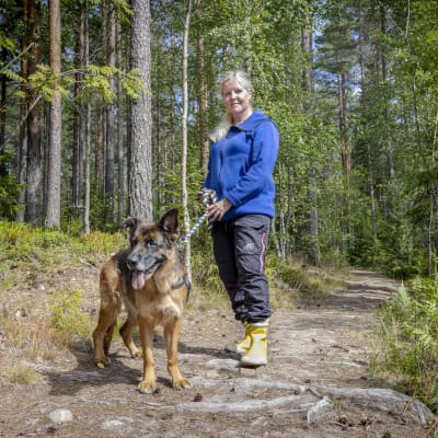 Nainen (Tanja Kammarback-Rossi Karjaalta) on koiransa kanssa metsäpolulla.