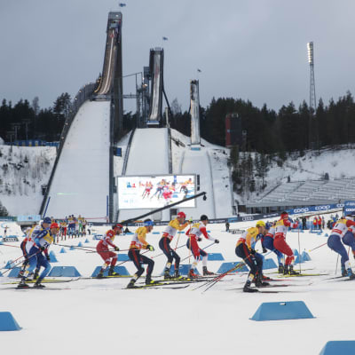 Kilpailijat hiihtävät Lahden hiihtostadionin kaarteessa.