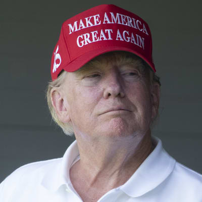Donald Trumpilla on päässään punainen lippis, jossa lukee Make America Great Again.