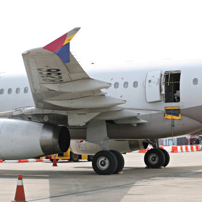 Kuva Asiana Airlines -lentoyhtiön lentokoneesta Soulin lentokentällä 26. toukokuuta 2023. Matkustamon ovi on auki ja sen aukkoon on vedetty keltamusta varoitusteippi.