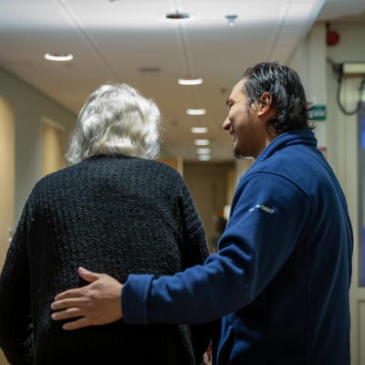 Närvårdare Bern Amar hjälper en äldre år 2018.