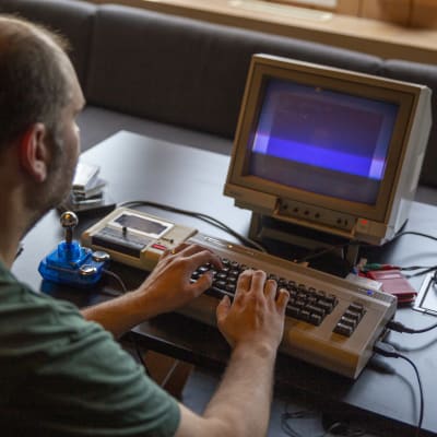 Ville Jouppi näppäilee Commodore 64 tietokonetta.