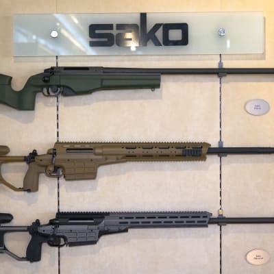 Sakon valmistamia TRG tarkkuuskiväärejä näyttelytilan seinällä.