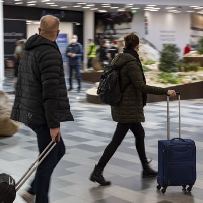 kiireisiä matkustajia Helsinki-Vantaan lentoaseman tuloaulassa.