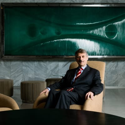 Gordon Guyatt istuu nojatuolissa, taustalla suuri taideteos.