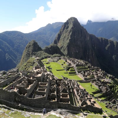 Ruinerna i Machu Picchu med berg i bakgrunden.