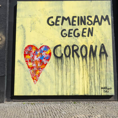 En väggmålning i Berlin med texten tillsammans mot corona
