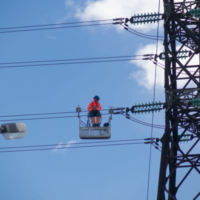 En elektriker är uppe på en högspänningslinje