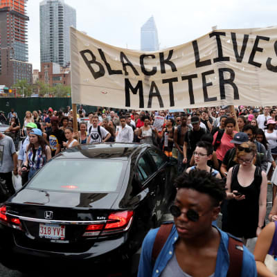 Mielenosoittajia kadulla, "Black lives matter" -kyltti