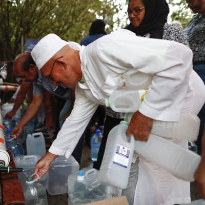 Invånare i Kapstaden, som lider av vattenbrist, fyller vattensflaskor med vatten från en bergskälla