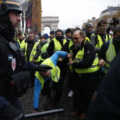Polisen stoppar demonstranter på  Champs-Élysées på lördag förmiddag.