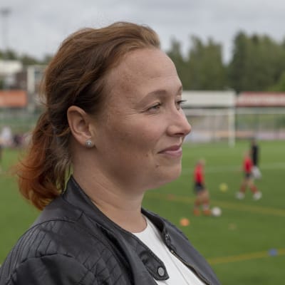 Jalkapalloa harrastavan pojan äiti Helena Sarso sivuprofiilikuvassa, kuvattu Espoonlahden urheilupuistossa.