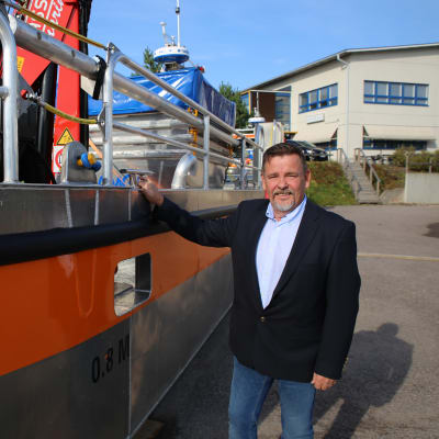 Lamor oy:n varatoimitusjohtaja Juha Muhonen ja öljyntorjunta-alus, joka on lähdössä Grönlantiin.